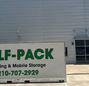 SELF-PACK Moving and Mobile Storage container stored in parking spaces in front of large building on a sunny day